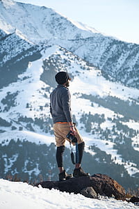 man standing on rock holding camera thumbnail