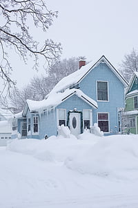 blue wooden house covered with snow thumbnail