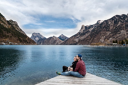 man and woman sitting on wood dock thumbnail