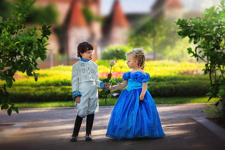 boy in white suit giving flower to a girl in blue gown thumbnail