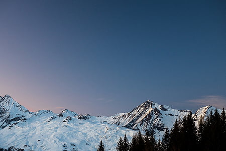 mountain ranges with snow beside trees thumbnail