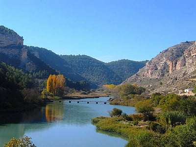 calm body of water surrounded with mountains thumbnail