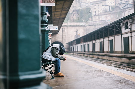person sitting on black bench in train station thumbnail