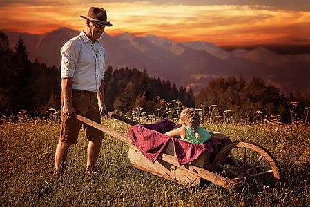 girl riding wooden wheelbarrow during sunset thumbnail