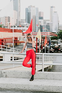 woman standing on pavement leaning on handrail thumbnail