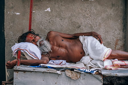 topless man with white pants lying on the bed thumbnail