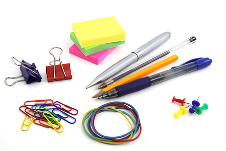 three pens and yellow pencil beside sticky notes and two binder clips beside paper clips and rubber bands thumbnail