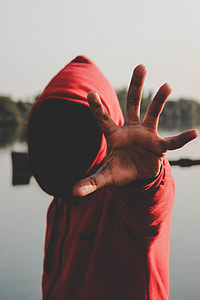 man wearing reaching his hand standing beside body of water thumbnail