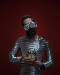 man standing holding gray alarm clock thumbnail