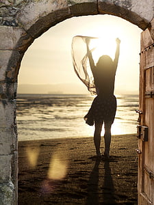 woman in black long-sleeved dress on sand during daytime thumbnail