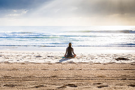 woman sitting on seashore under white sky and blue clouds at daytime thumbnail