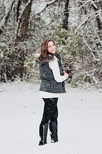 woman standing on snow field near trees thumbnail