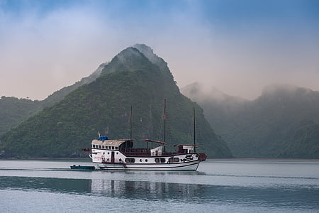 white boat near green mountain thumbnail