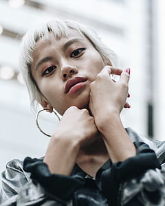 closeup photography of woman wearing gray and black long-sleeved shirt and hoop earrings thumbnail