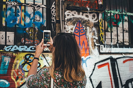 woman taking picture of wall art thumbnail