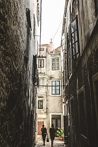 narrow pathway surrounded with concrete building thumbnail