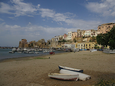 several boats on sand overlooking buildings at daytime thumbnail