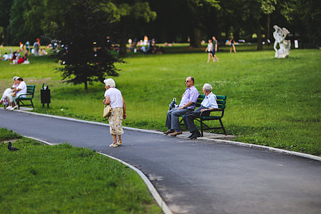 man and woman sitting on green metal bench near park during daytime thumbnail