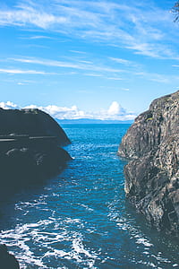 body of water near rock formation during da ytime thumbnail