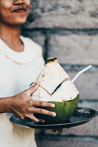 smiling woman carrying and holding coconut juice thumbnail