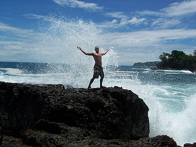 man wearing cargo shorts standing on cliff near waterfalls thumbnail