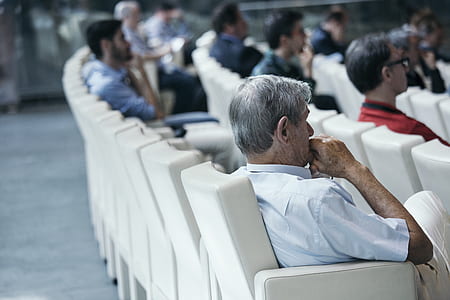 person wearing white collar top white sitting on white leather armchair thumbnail