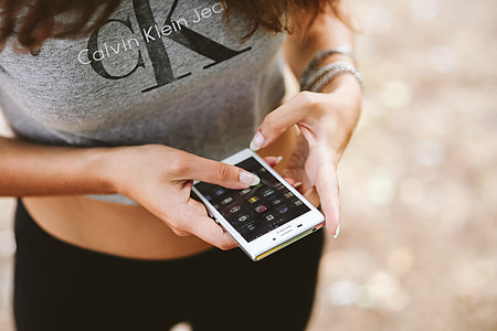 Young woman holding the white mobile phone thumbnail