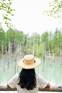 person in white shirt in brown wooden rail during daytime thumbnail