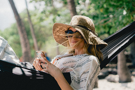 woman lies on hammock outdoor during day thumbnail