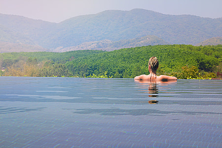 woman in infinity pool watching at trees thumbnail