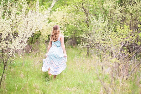 woman surrounded by green trees and white flowers thumbnail