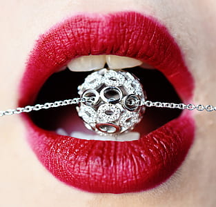 person's opening mouth with silver-colored accessory on mouth thumbnail