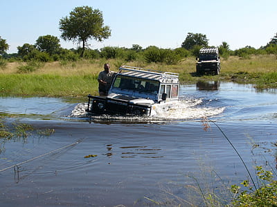 black monster truck on body of water during daytime thumbnail