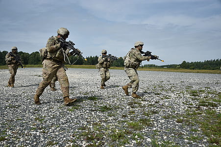 soldiers holding rifles walking on grass thumbnail