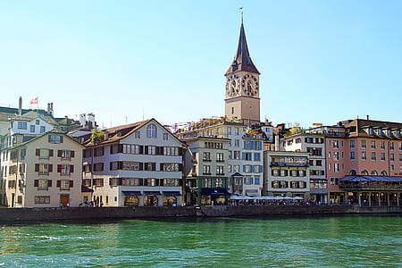 clock tower in city near body of water thumbnail