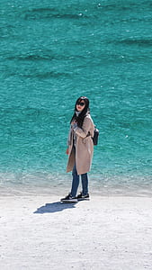 woman standing near body of water thumbnail