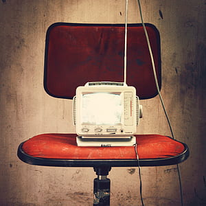 white CRT television on red chair thumbnail