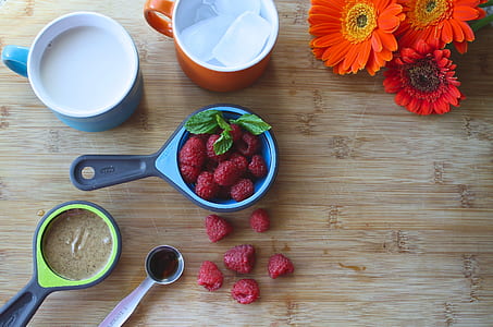 flat lay photo of raspberries inside blue measuring cup thumbnail