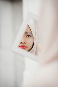 woman watching herself in front of rectangular white framed mirror thumbnail