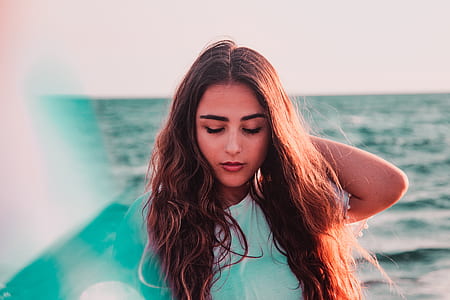 woman holding her head near water thumbnail