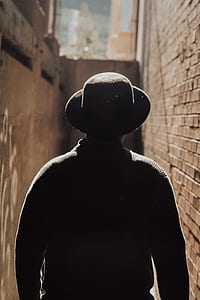 man wearing brown hat walking in pathway thumbnail