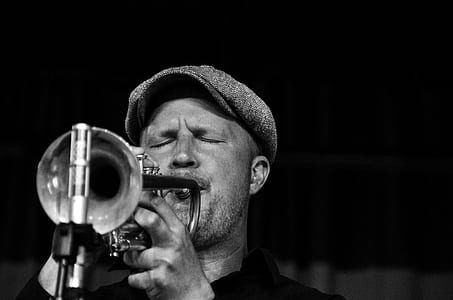 grayscale photo of man playing trumpet thumbnail