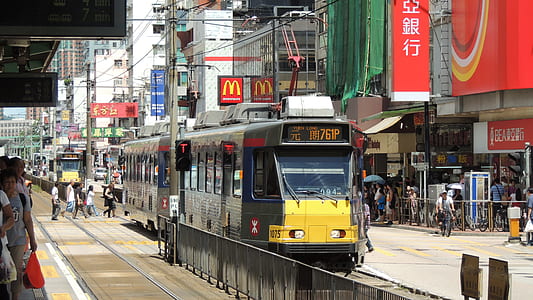 yellow and grey tram beside structures thumbnail