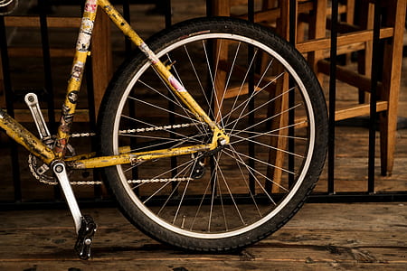 black and yellow bicycle near black steel grill fence thumbnail
