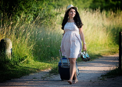 woman pulling luggage and and holding her shoes while walking with her barefoot thumbnail