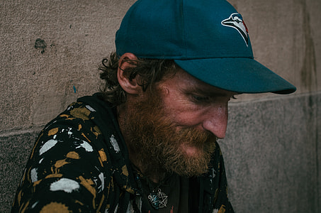man with hat leaning on wall thumbnail