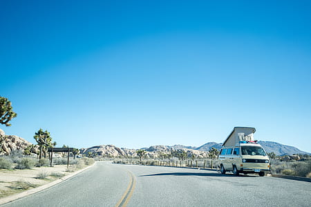 yellow van on road side near grass during daytime thumbnail