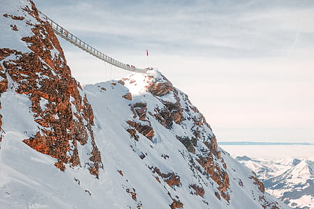 hanging bridge between mountain covered with snow thumbnail