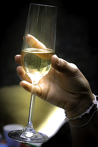 person holding clear flute champagne glass filled with yellow liquid thumbnail