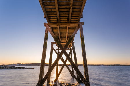 brown wooden dock on body of water under blue sky thumbnail